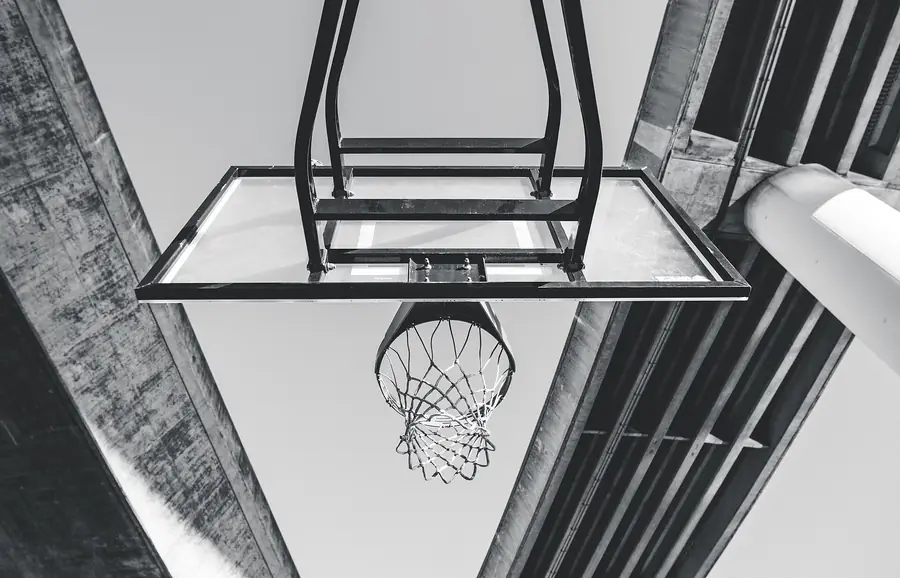 Basketballkorb von unten fotografiert, Hallendach in Schwarzweiss